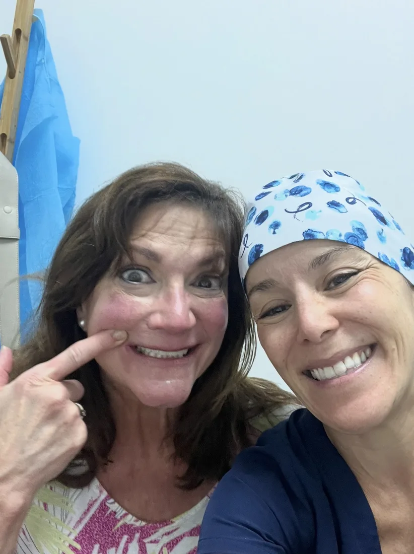 Smiling patient with a member of the dental team at the clinic.