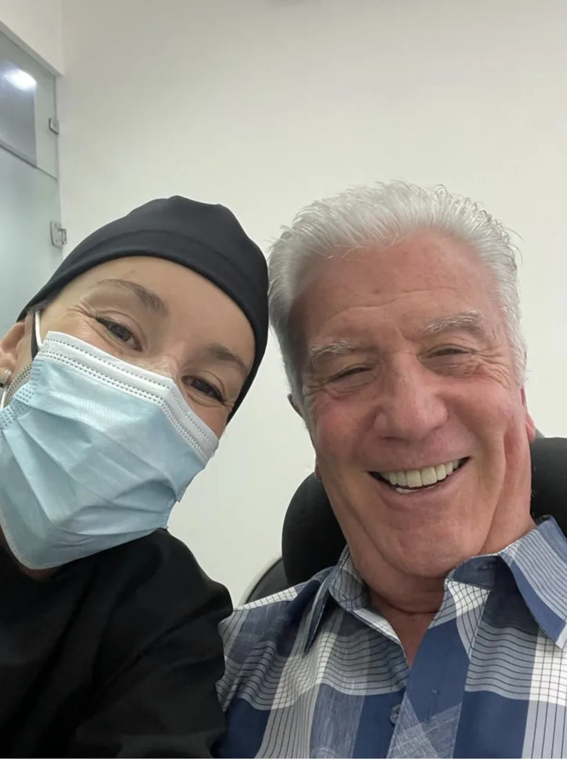 Smiling patient beside a clinician at the clinic.